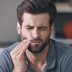 Man holding jaw in pain