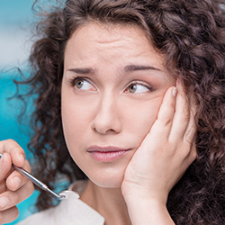 Woman holding cheek in pain